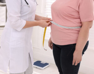 doctor measuring an overweight woman's waist